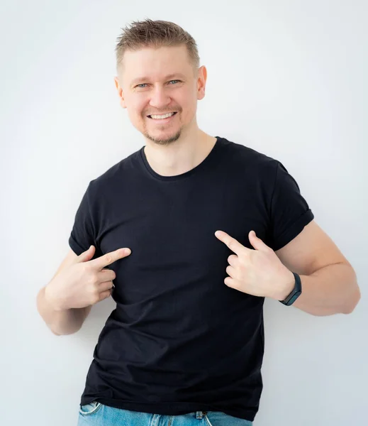 Homem atraente apontando para t-shirt — Fotografia de Stock