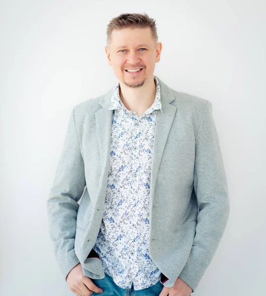 Gömlekli ve ceketli gülümseyen adam.