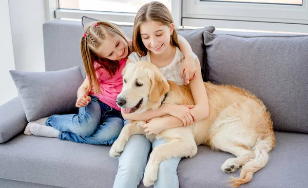 Sorrindo meninas abraçando lindo cão — Fotografia de Stock