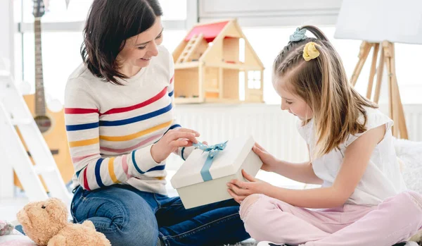 Mosolygó anya kinyit gyönyörű ajándékot — Stock Fotó