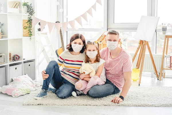 Famiglia che indossa maschere nella stanza dei bambini — Foto Stock