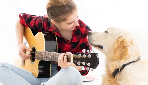 Usmívající se dívka hraje na kytaru roztomilému psovi — Stock fotografie