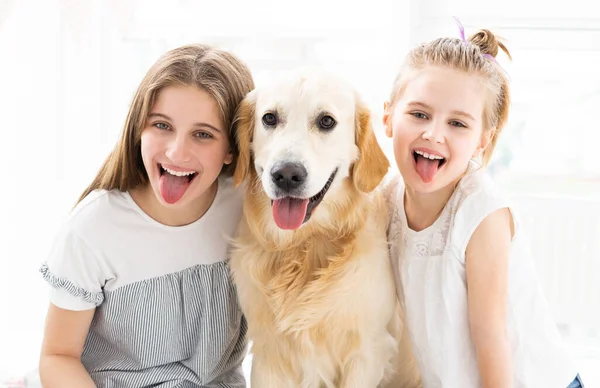 Leende systrar med söt hund — Stockfoto