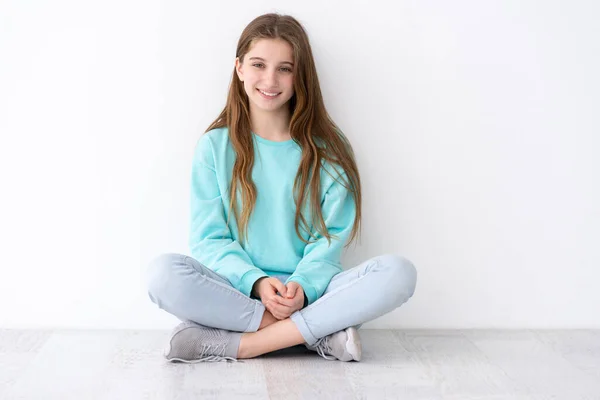 Mooi tienermeisje zittend op de vloer — Stockfoto