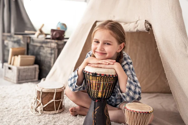 Söt liten flicka med etniska trummor — Stockfoto