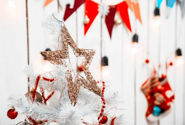 Hračka hvězda na vrcholu vánočního stromku ve zdobené místnosti — Stock fotografie