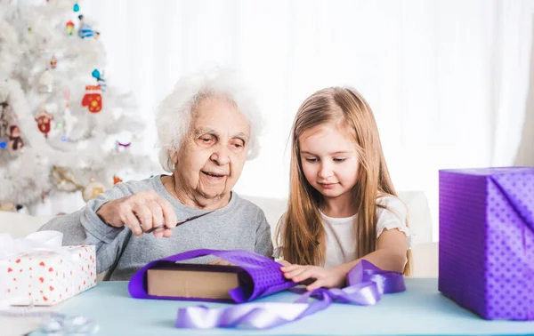 Abuela con nieta cubrir regalos — Foto de Stock