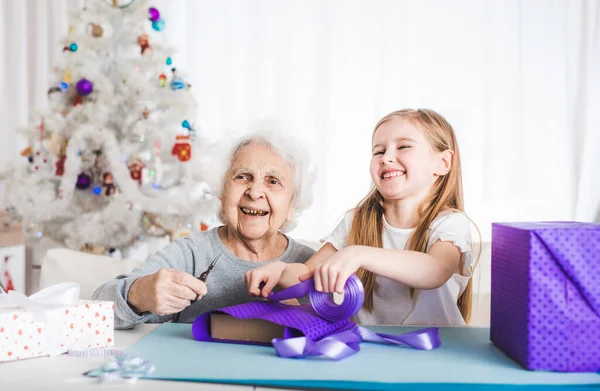 Abuela con nieta decorando regalos — Foto de Stock