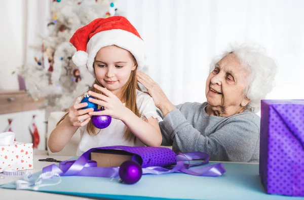 Nieta sentarse con la abuela sosteniendo bolas — Foto de Stock