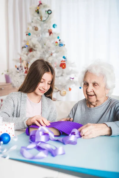 Ґандочка допомагає бабусі прикрашати подарунки — стокове фото
