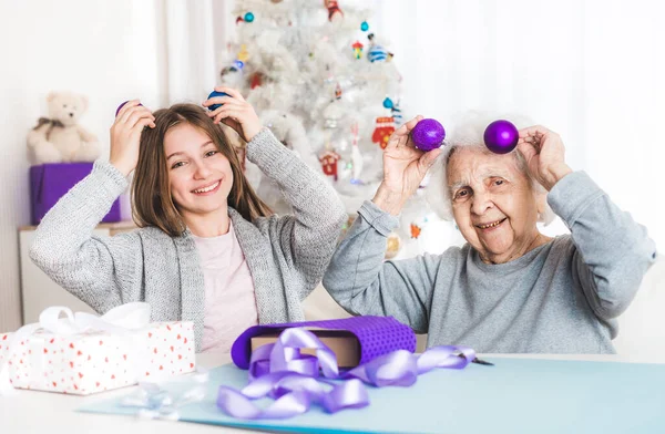 Nieta sosteniendo bolas en la cabeza con la abuela — Foto de Stock