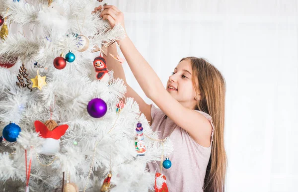 Tonårstjej dekorerar julgran — Stockfoto