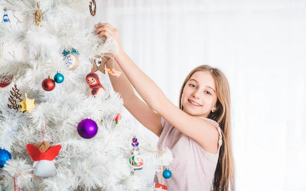 Teenage girl decorating christmas tree — Stock Photo, Image
