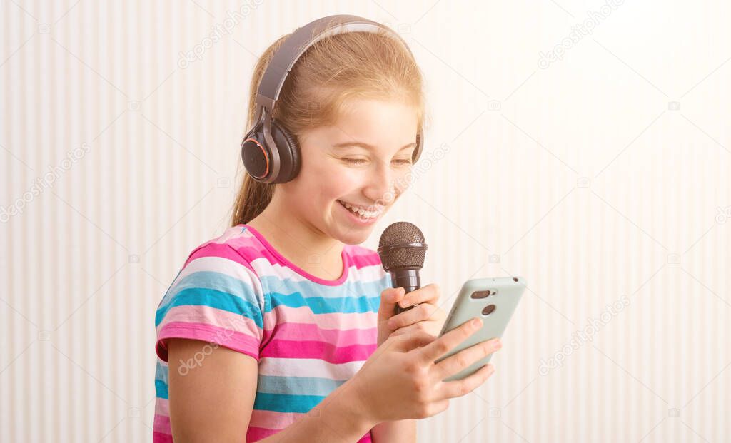 Girl holding phone in one hand and microphone in another