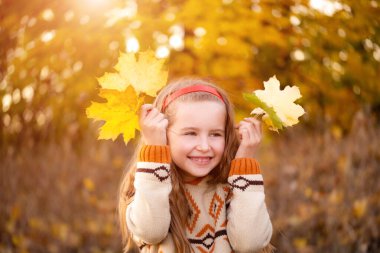 Sonbahar yapraklarıyla oynayan çocuk