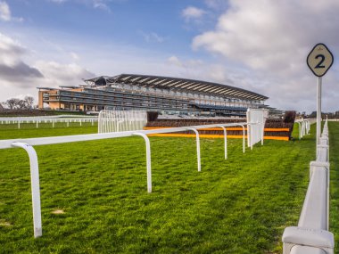 Ascot Racecourse, Ascot, Berkshire, England - February 2019 View of course and Grandstand. With fence and green grass. clipart