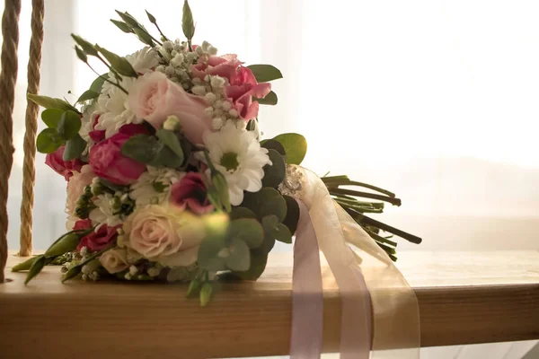 Wedding bouquet close-up on indoor swing on romantic wedding background selective focus