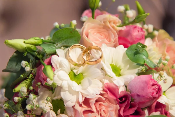 Wedding Rings on lovely natural flowers bouquet