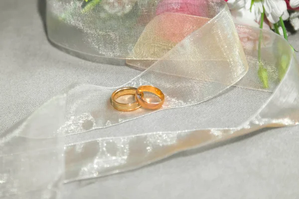 Wedding Rings near the lovely natural roses bouquet background