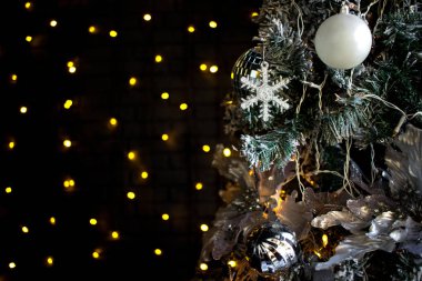 Çam ağacı Noel oyuncaklar. Beyaz kar tanesi, turuncu ışık Ampüller ve topları. Koyu arka plan.