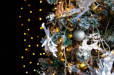 Çam ağacı Noel oyuncaklar. Beyaz geyik, turuncu ışık Ampüller ve topları. Koyu arka plan.