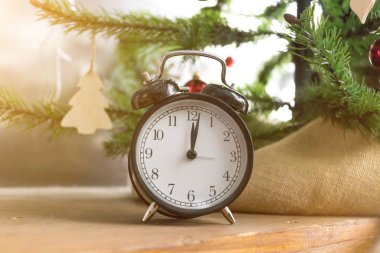 Ahşap masa Noel ağacı arka plan üzerinde siyah çalar saat. Yeni yıl Tema