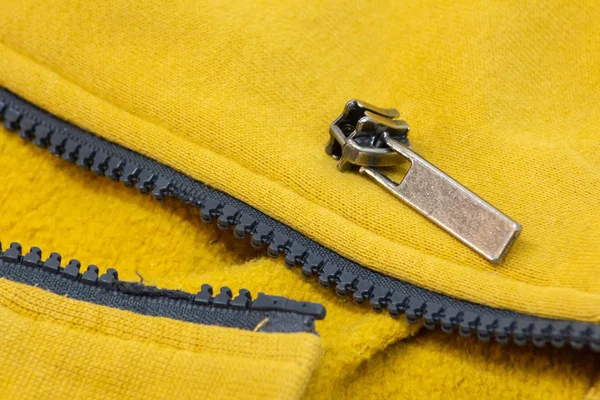 노란색 셔츠 자 켓에 깨진된 지퍼입니다. 자세하게 클로즈업 사진. 스톡 이미지