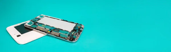 Tablet repair. Close-up disassembled mobile phone parts. Colorful blue background. Space for text.