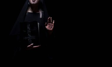 Cadı elinde pentagram sembollü bir büyü kitabı tutuyor. Cadılar Bayramı, kara büyü kavramı. Siyah izole edilmiş arkaplan modeli.