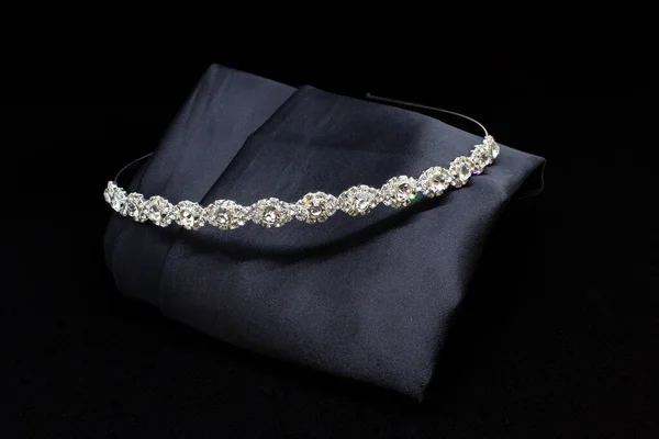 White silver diamonds gemstone hair band tiara on black background. Jewellery close-up display isolated concept