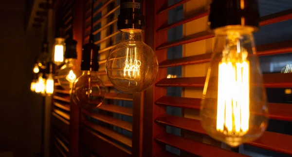 Karanlıkta altın gibi parlayan antik Edison tarzı ampuller. Aydınlatma konsepti. Vintage ampul. Retro ışıkların bulanık arkaplanı — Stok fotoğraf