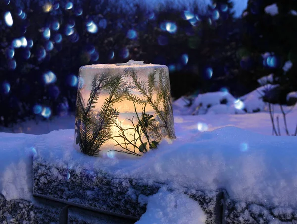 冰冻的冰灯与雪中的云杉树枝 用烛光点燃 — 图库照片