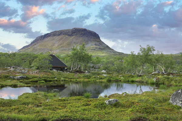 Saana fell and trekker's hut in summer evening light, seen from Lake Tsahkal
