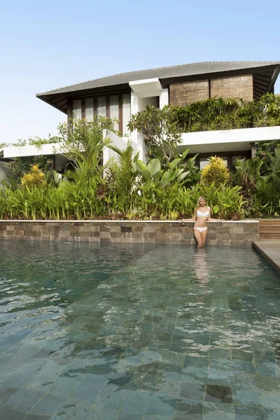 Modelo em roupa de banho posando em uma piscina enorme — Fotografia de Stock