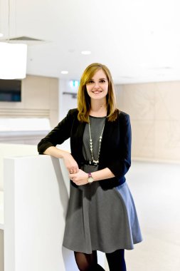 Ofisteki hoş kadınlar siyah giyinmiş ve gülümsüyor. 