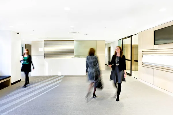 Moderna sala de recepção com três mulheres em movimento — Fotografia de Stock