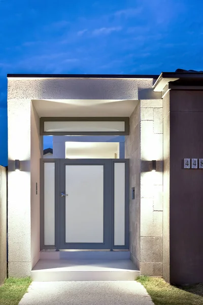 Front of a modern house entrance with lights on — Stock Photo, Image