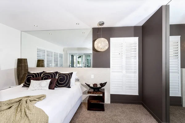 Современная спальня с белыми простынями и подушками — стоковое фото