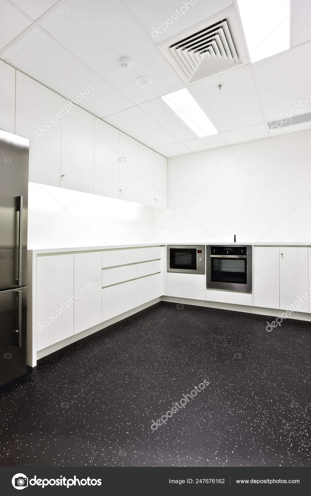 Modern Kitchen With White Walls And Black Floor Tiles Stock Photo