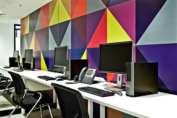 Bureau informatique moderne avec centre d'appels avec mur coloré — Photo