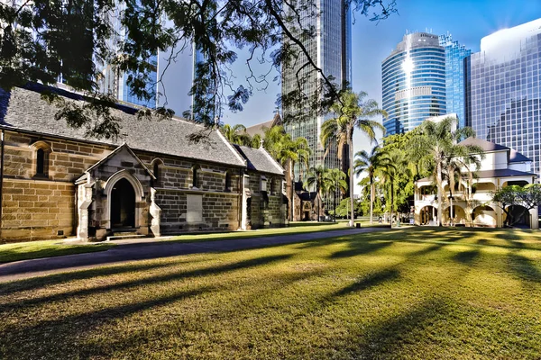 Velho gramado da igreja perto dos edifícios modernos da cidade — Fotografia de Stock