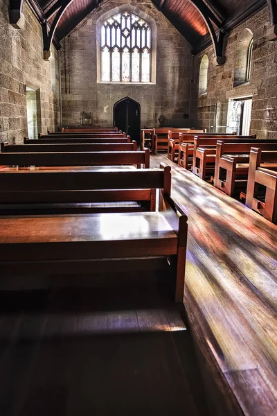 Panchine in legno di una vecchia chiesa in pietra — Foto Stock