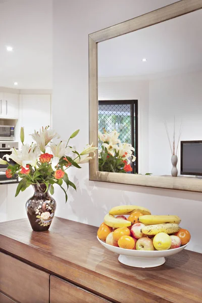 Kolorowe ściany lustro i owoców talerz na stole — Zdjęcie stockowe