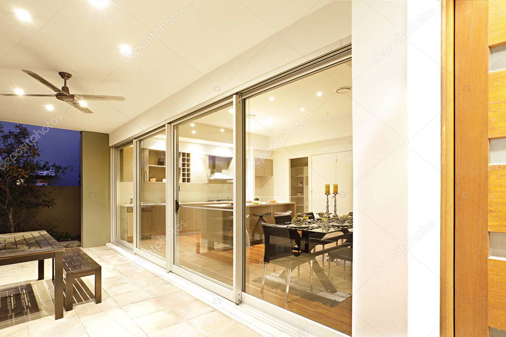 Entrance of modern apartment with glass doors and furnitures.