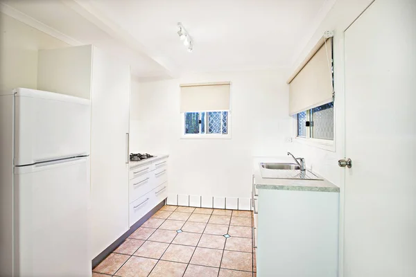 Compacte witte ingerichte keuken met betegelde vloer — Stockfoto