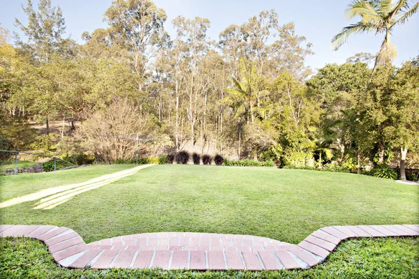 Gemauerter Weg durch einen formell gepflegten Garten — Stockfoto