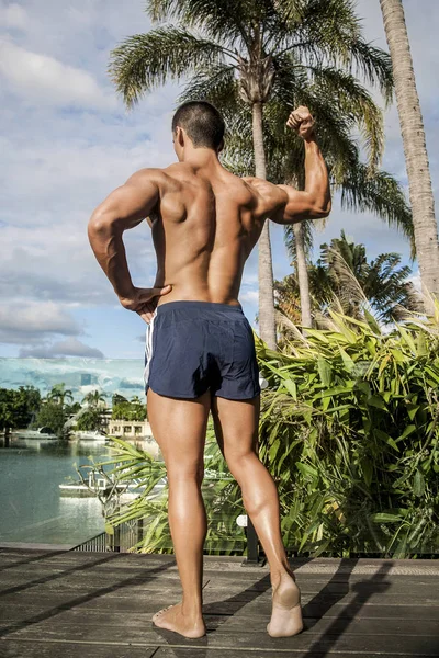 Bodybuilder steht mit einer Hand nach oben — Stockfoto