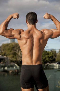 Yetenekli antrenör vücudunun güçlü olduğunu gösteriyor.