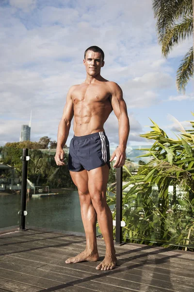 Güçlü vücutlu bir adam yerde duruyor.