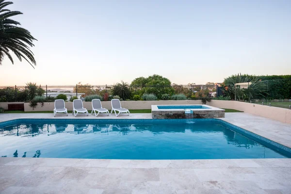 Piscina de lujo con una pequeña fuente cubierta con valla — Foto de Stock